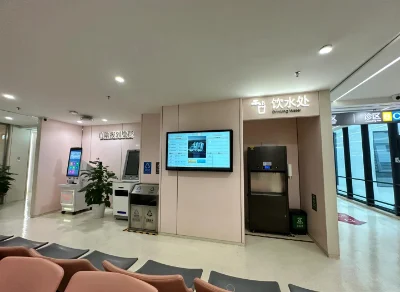 An unoccupied check-up centre corridor with seating, self-service kiosks and drinking water.