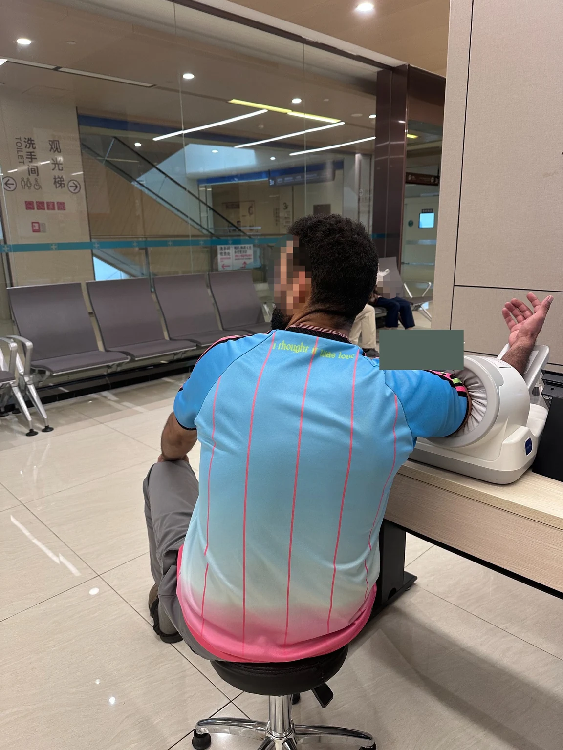 A moment during Omar’s hospital examinations, with his face and the device display obscured