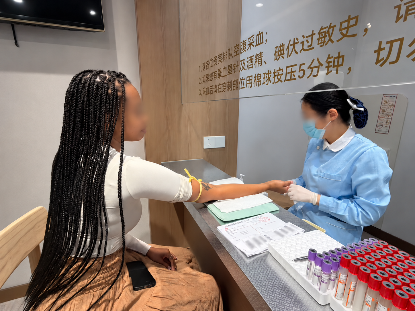 A blood draw during the Shanghai health check-up, with the visitor’s facial area lightly blurred